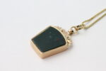 Anheng i gult gull med grønn sten