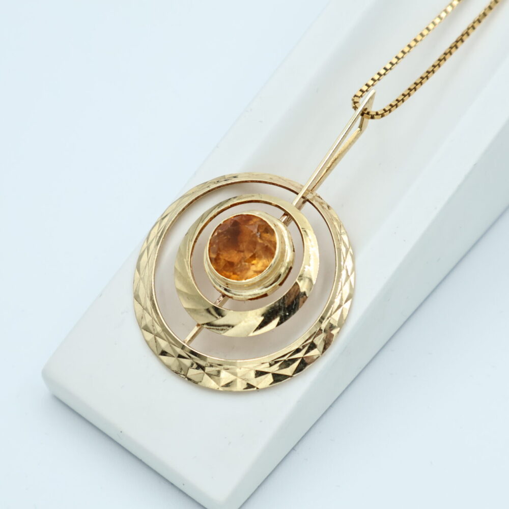 Anheng i gult gull med oransje stein